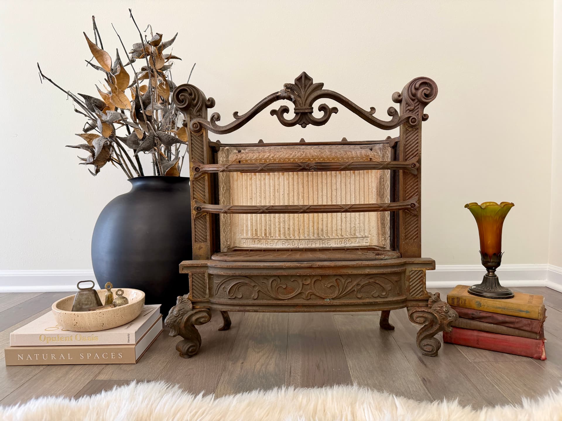 Antique Humphrey Radiantfire cast iron heater with books, vessels and an amber lily lamp