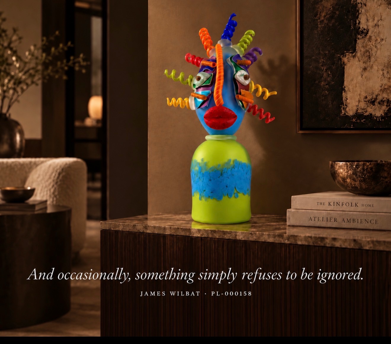 James Wilbat glass sculpture of a face with colourful spiral hair, on a marble console